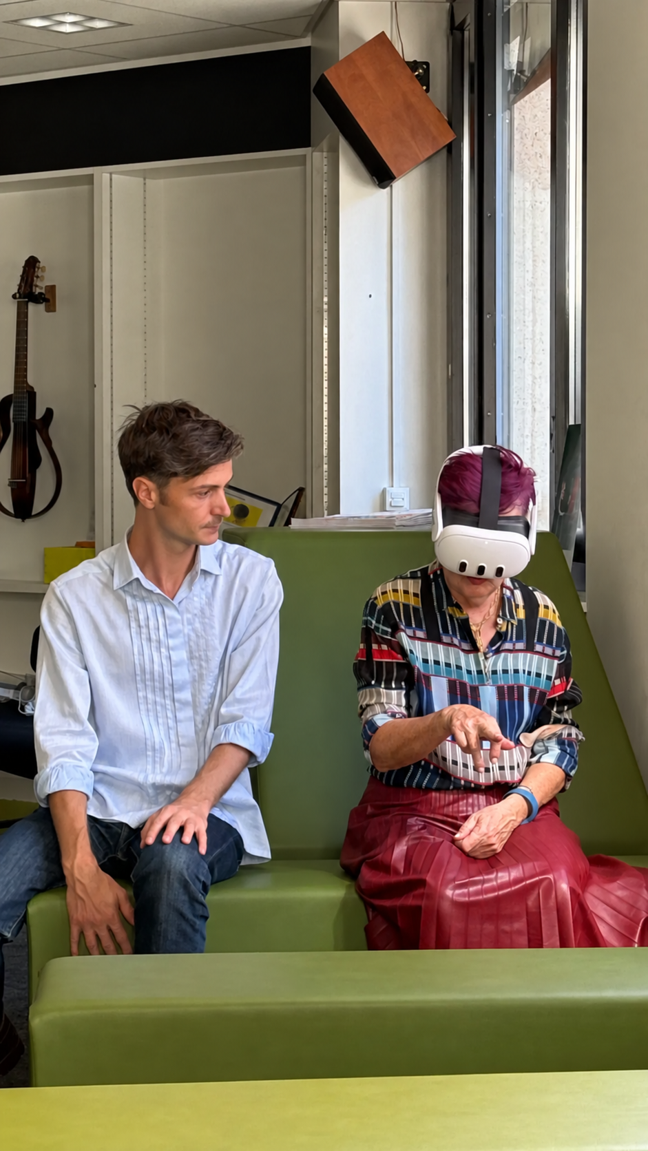 Une personne découvre Virtual Hall avec un casque de réalité virtuelle à la BM Cité de Genève, accompagnée d’une médiatrice.
