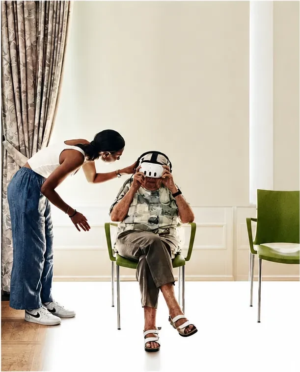 A mediator assists a nursing-home resident wearing a virtual reality headset.